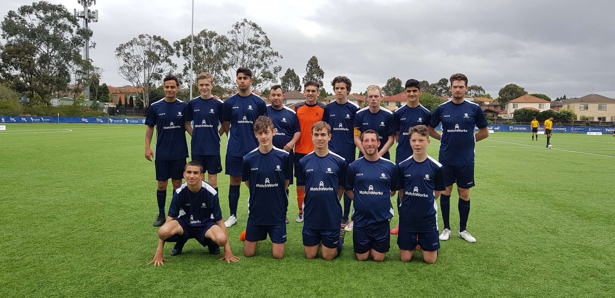 A group of men at the 7 a side football team championships standing together on a green field