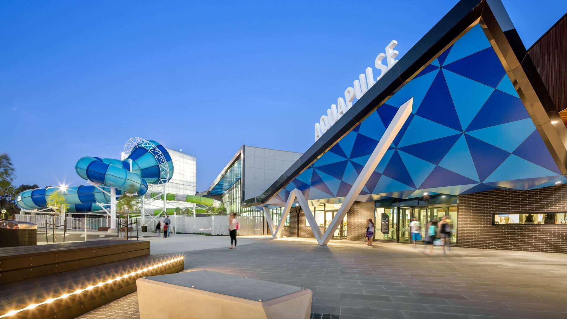 Aquapulse entry with blue water slide, blue triangle shapes above entry.