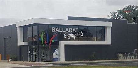 Exterior of Ballarat Gymnastics building featuring large windows and vibrant signage against a modern gray facade.