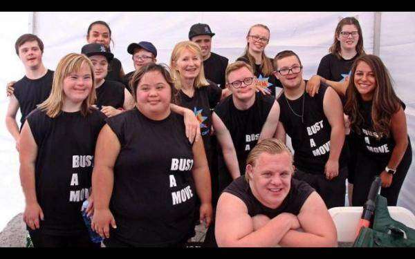 A group of adults in black dance shirts.