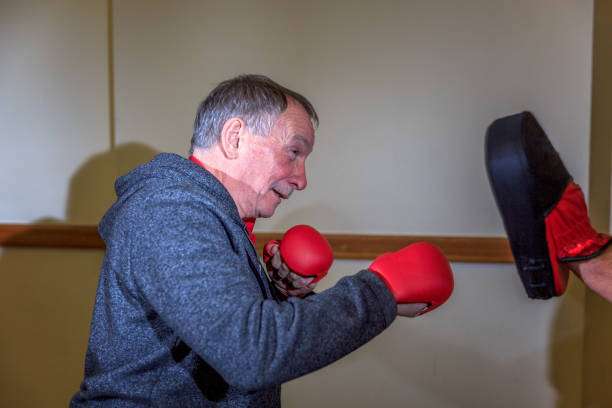 Photo of a man with red boxing gloves, getting ready to punch a boxing mit