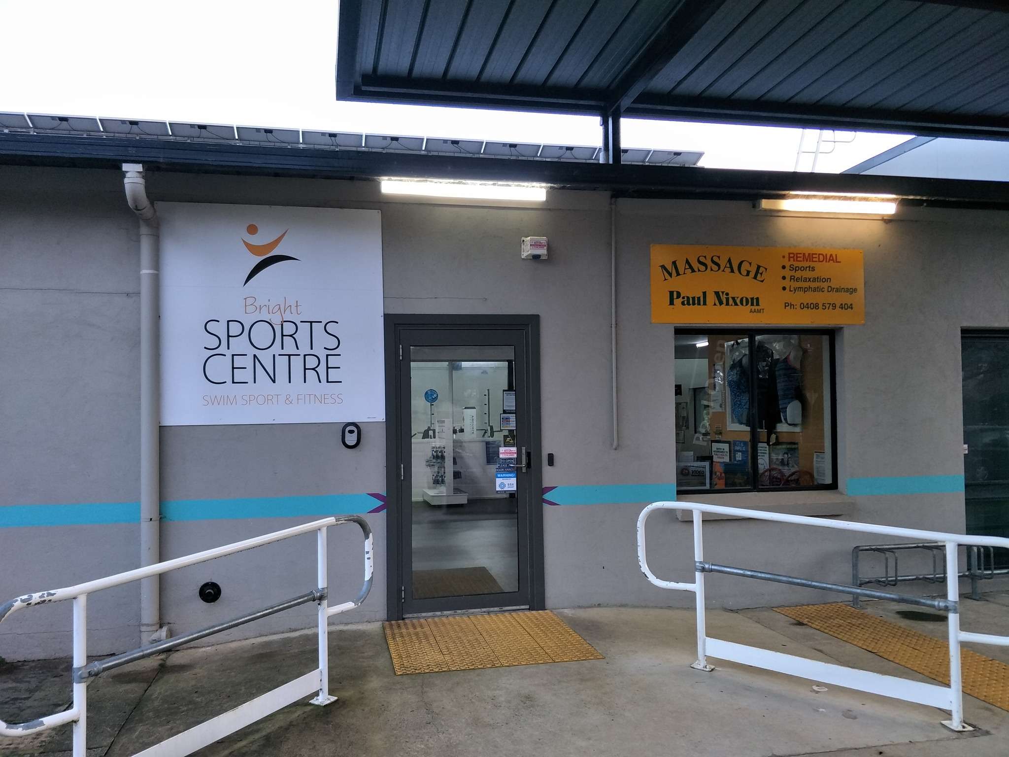 a grey buildings with accessible ramps and grab rails.