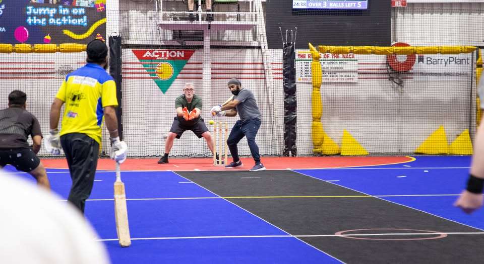 A group of indoor cricket players on the court.