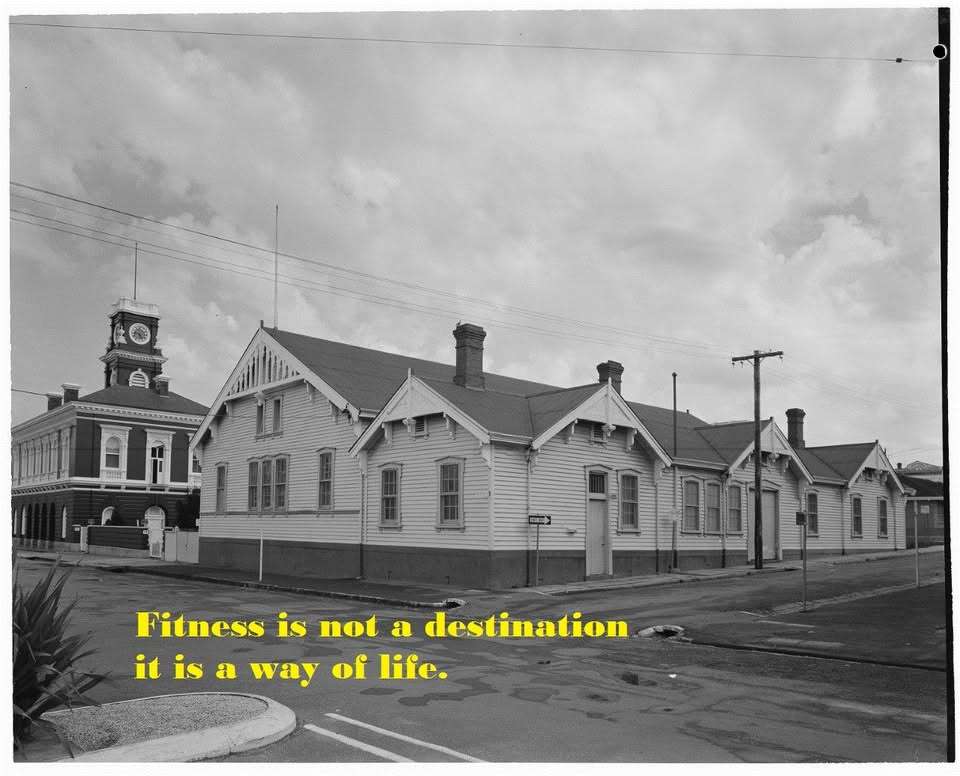 A large white weatherboard centre surrouned by a black road.