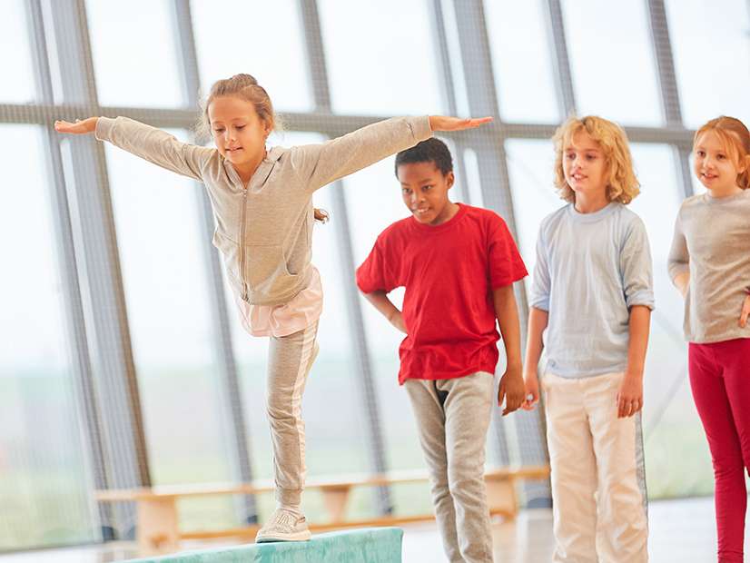 YMCA gymnastics photo of four children lining up for the beam apparatus