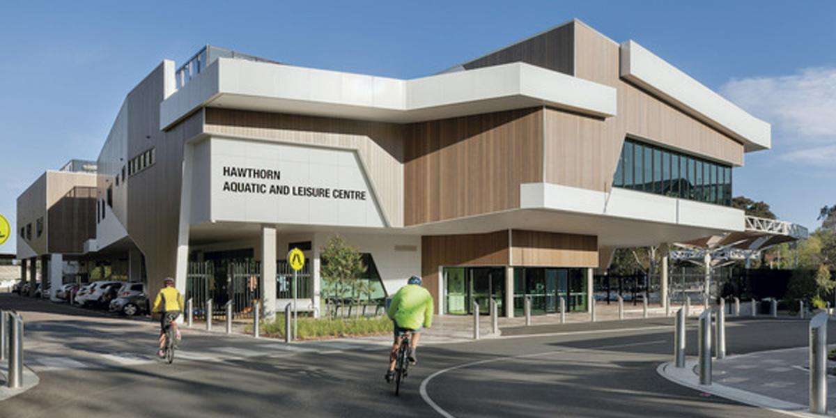 A large beige building surrounded by roads and street signs.