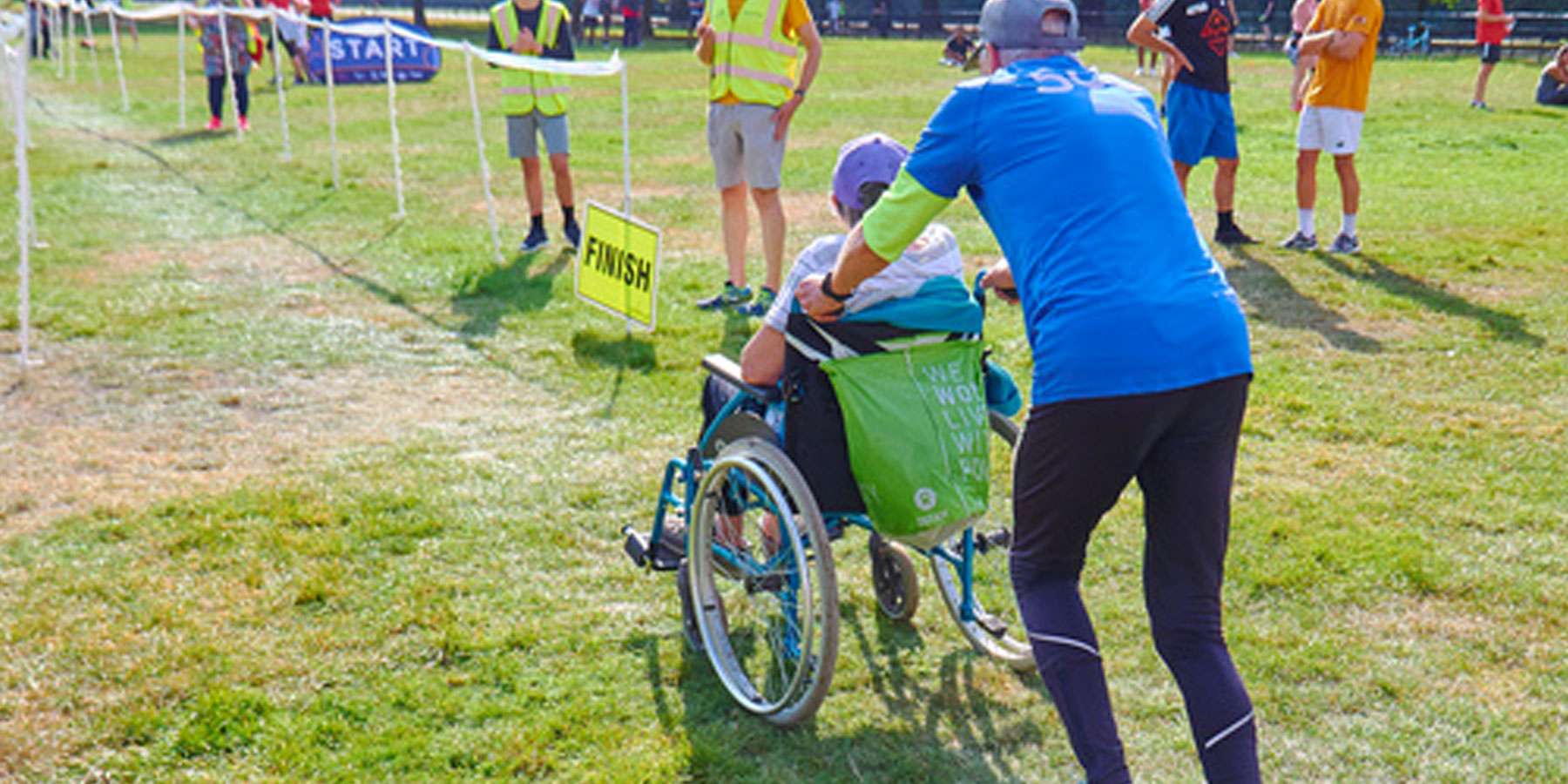 Person running and pushing a person in a wheelchair