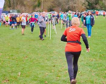 Image taken from behind a group of people running in an open green space