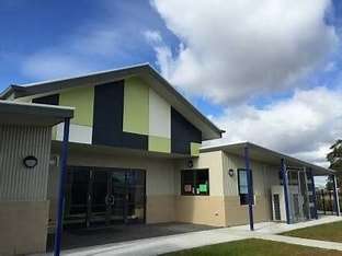 Image displays Hume Valley School with a blue sky and white clouds in the background