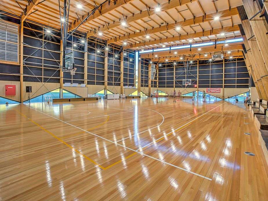 a large basketball court with bright lights and shiny floor.