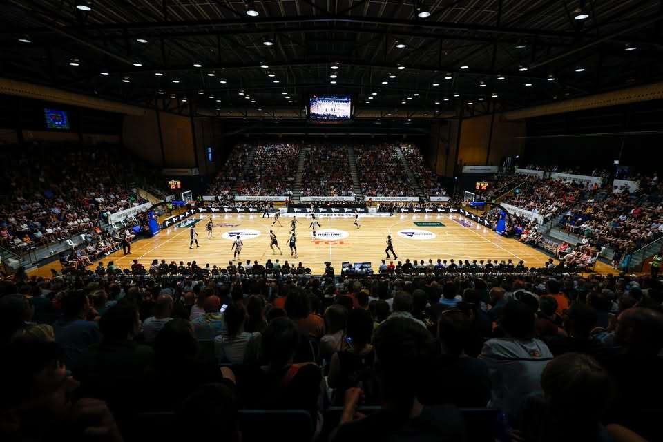 a large basketball court with bright lights and shiny floor.