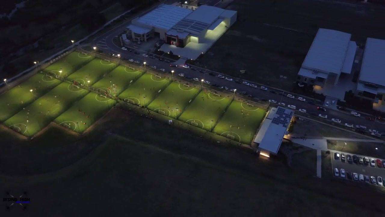 an aerial shot of 10 soccer fields with bright lights.
