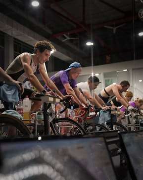Image displays 6 people on spin bikes in an indoors space