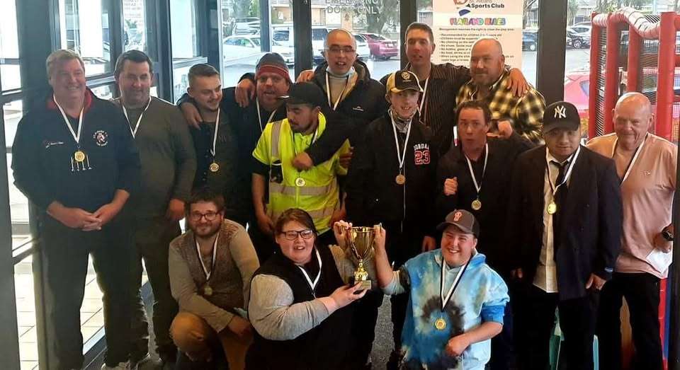 A group of people holding a trophy and smiling.