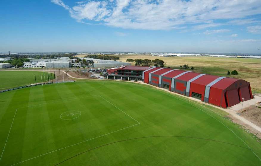 Indoor facilities at the hangar on the right side in red buildings set next to a large green oval