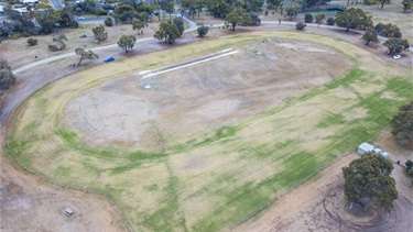 A large grassed reserve surrounded by trees.
