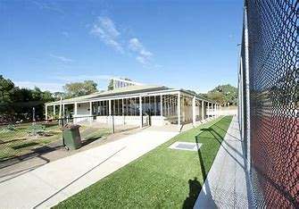 Image displaying the Wandana Heights Tennis Club Building, you can see a short green grass, a footpath and the tennis courts in the background