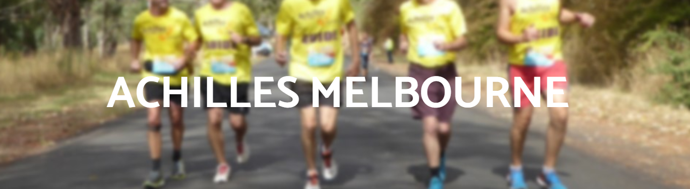 A group of runners in yellow shirts jog on a scenic road, promoting the Achilles Melbourne running community.