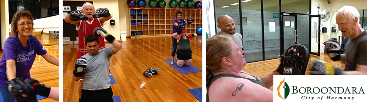 Participants engage in a fitness class, using weights and boxing gloves under the guidance of trainers in a lively gym setting.
