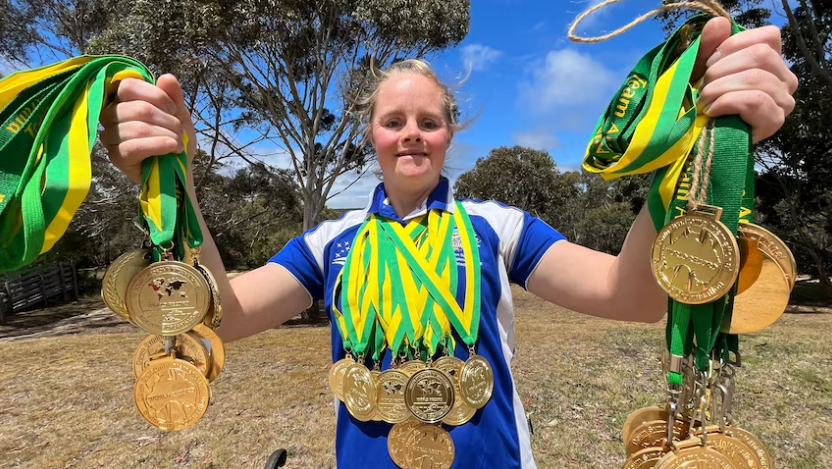 Phoebe Mitchell holding gold medals